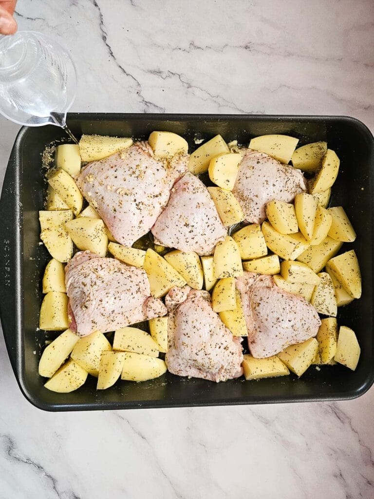 Greek Lemon Roasted Chicken and Potatoes in a baking tray