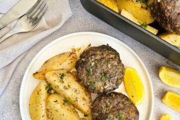 Biftekia with lemon potatoes on a plate