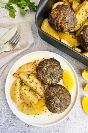 Biftekia with lemon potatoes on a plate