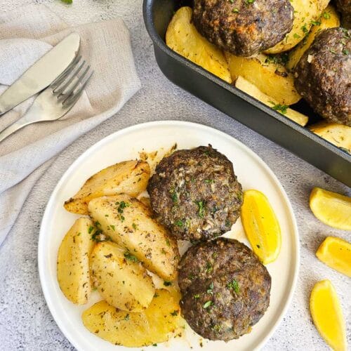 Biftekia with lemon potatoes on a plate