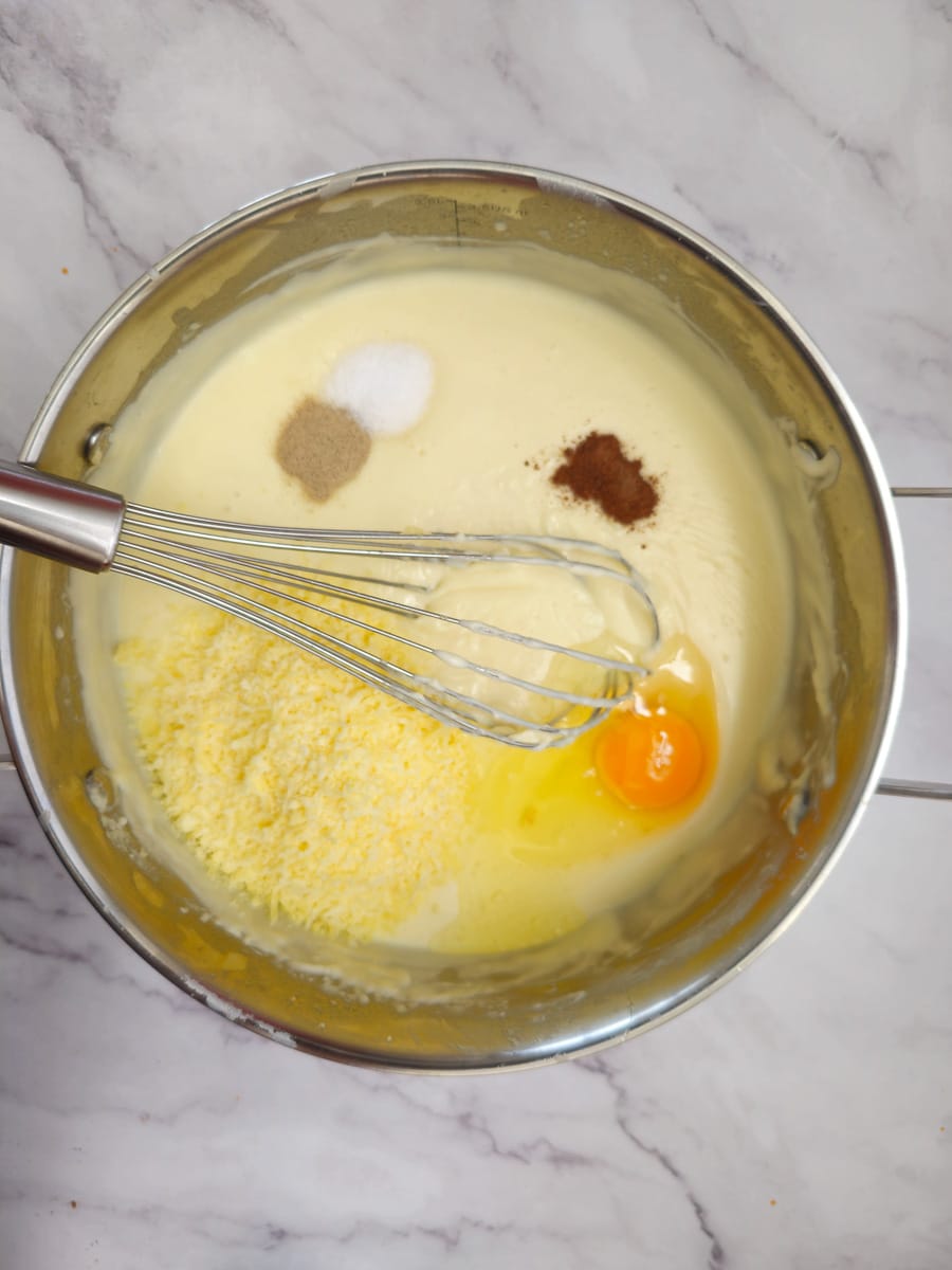 bechamel in pot adding cheese nutmeg