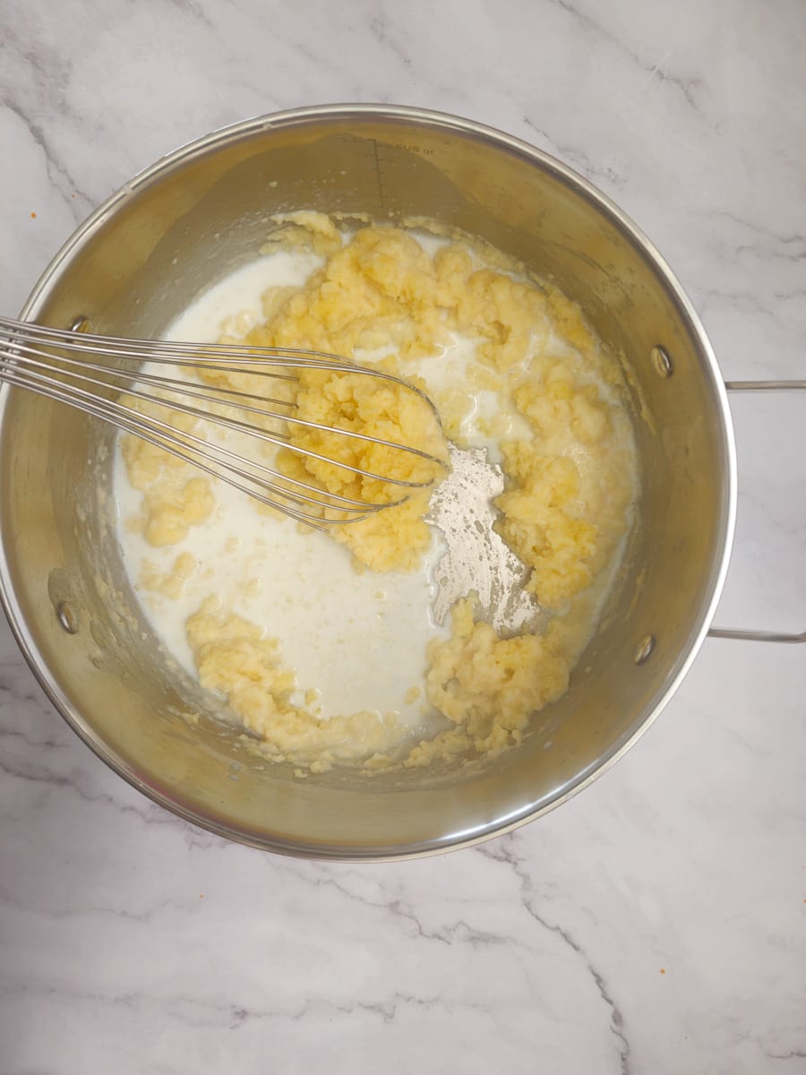 adding milk to roux in pot