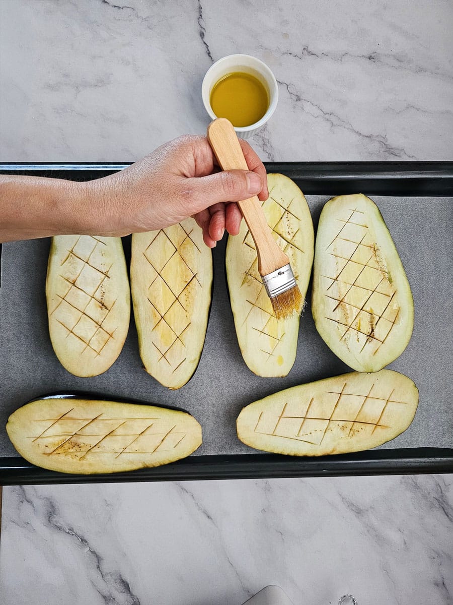 brushing eggplant halves with oil 