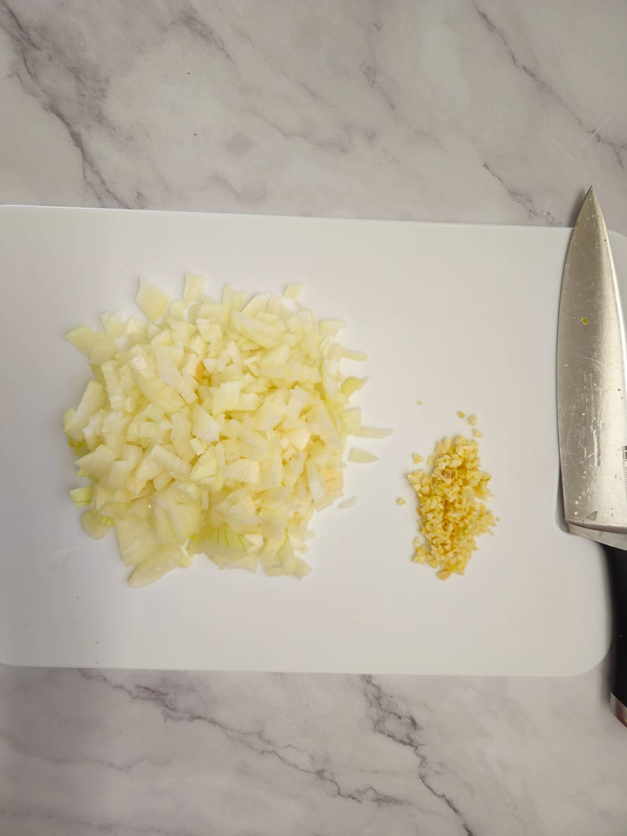 dicing onion and garlic on chopping board