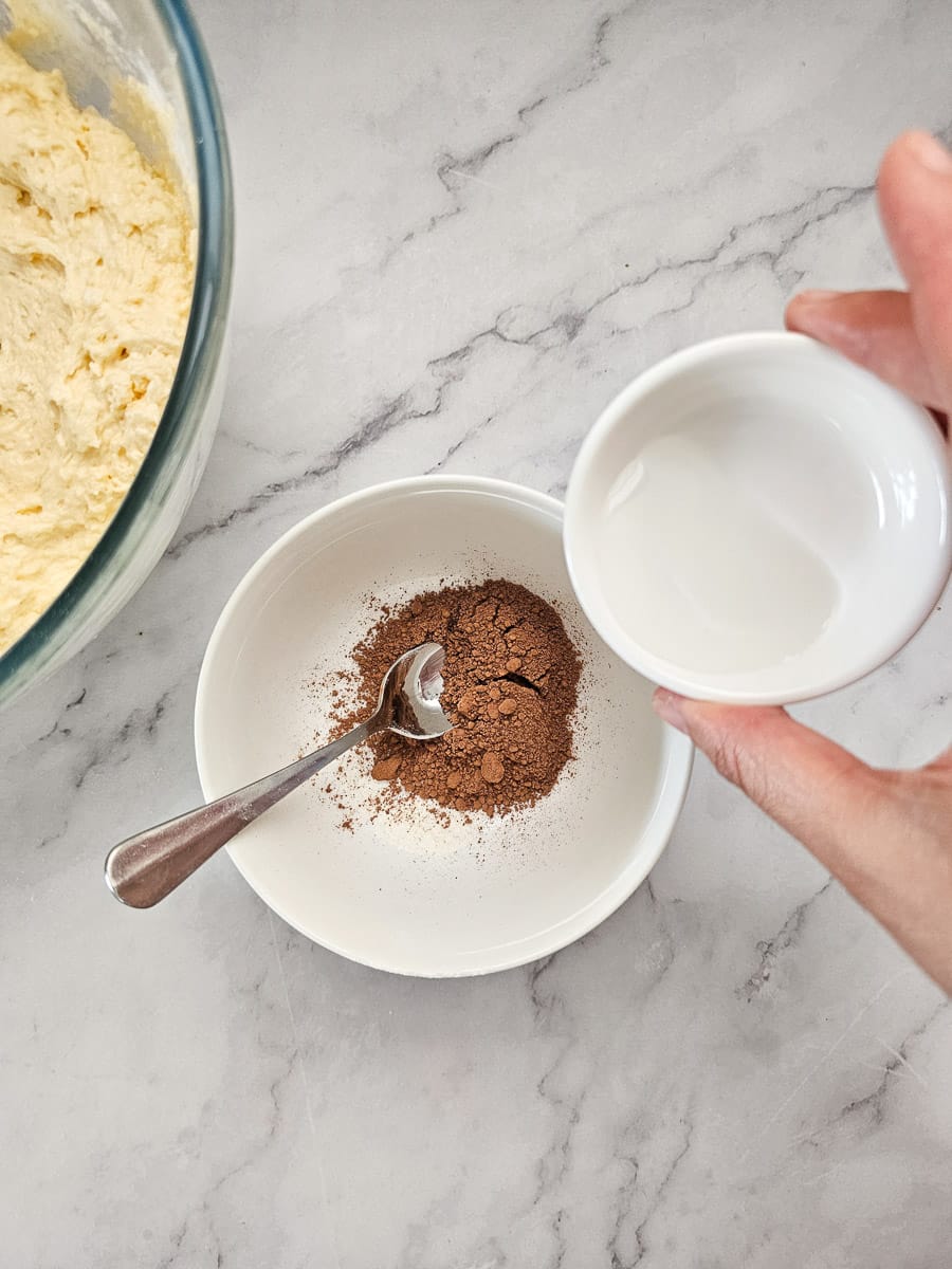 adding water to cocoa in a bowl